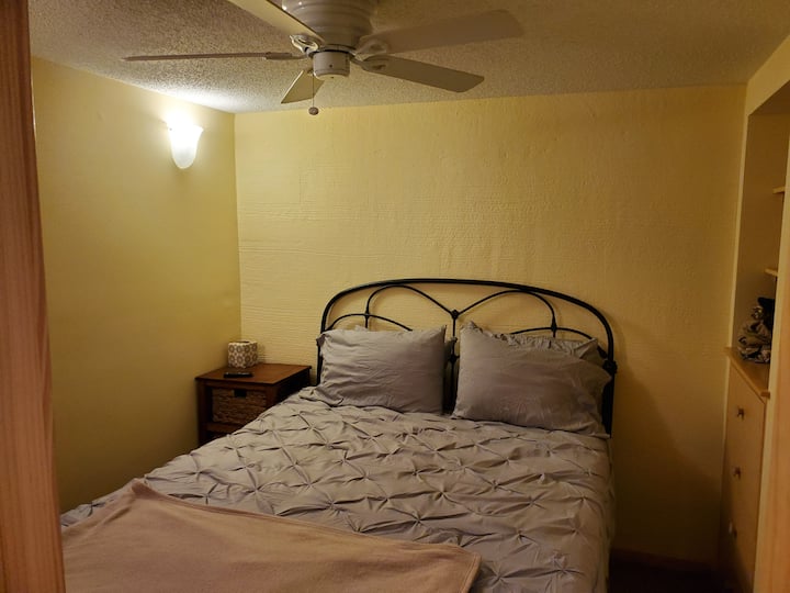 חדר שינה זוגי עם מאוורר תקרה וטלוויזיה בכבלים