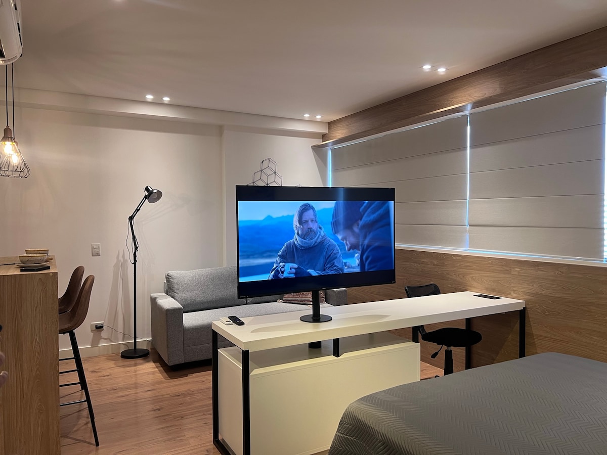 Mwonekano wa chumba cha kulala cha sebule chenye televisheni janja ya "50" iliyo na msingi wa mzunguko.