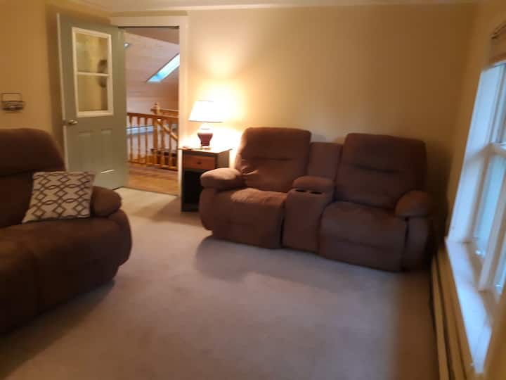 Dnevni boravak s pogledom na stepenice koje ulaze u kuću i dnevnu sobu s druge strane stepenica