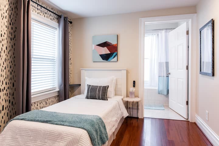 Charmante slaapkamer achter met 2 eenpersoonsbedden en een tv met Roku. 