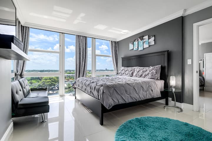 Dormitorio principal con TV por cable, ventanas grandes con vistas al atardecer /amanecer, vestidor