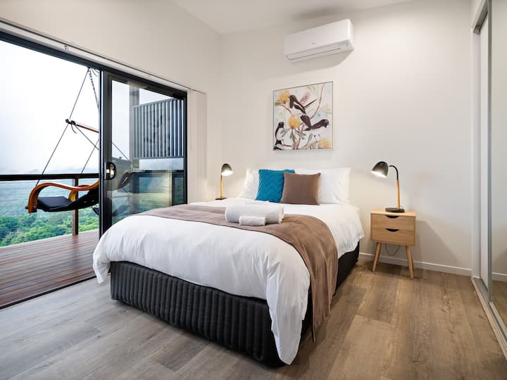 The bedroom with quality linen and queen size bed. 
Looking in from the living area and out onto the balcony and peaceful valley beyond. Everyone loves the hanging chair - relaxation guaranteed
