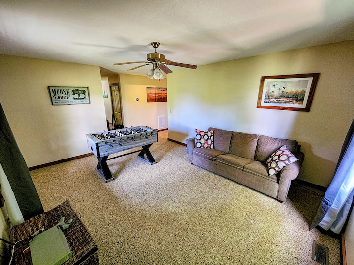 The lower floor living room features a gas fireplace, a 55" Roku TV, a classic PlayStation with 200 games, and a foosball table. You will have hours of indoor entertainment here!