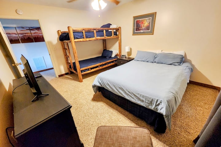 The lower floor bedroom 4 features one (1) QUEEN size bed and a twin bunk beds with a 32" Roku TV, as well as a chair.