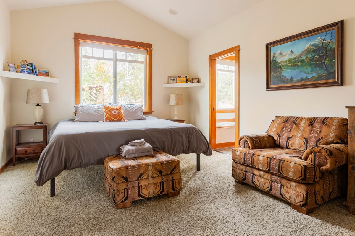 Суперголяма спалня на приземния етаж с голям уютен стол за почивка. 