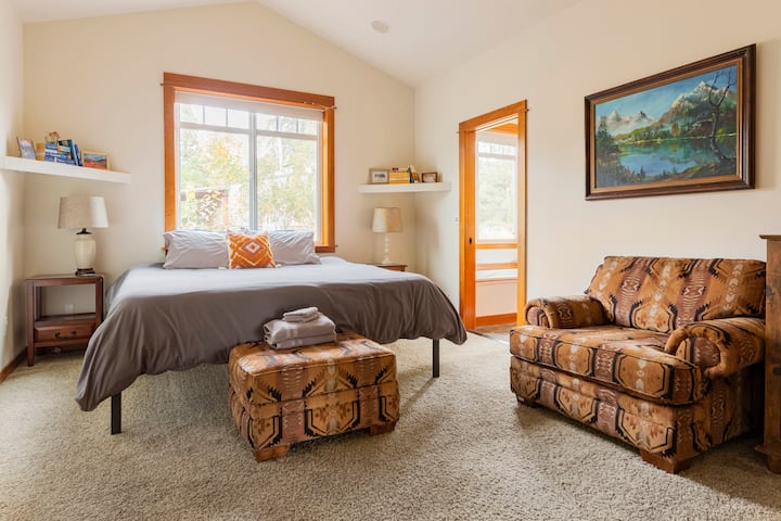 Chumba cha kulala cha ghorofa ya chini ya mfalme na kiti kikubwa kizuri cha kupumzika. 