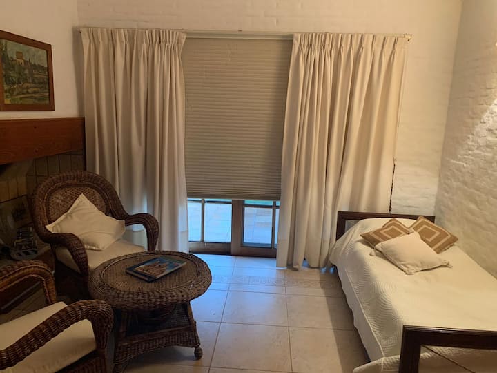 שולחן עם תנור עץ ושתי מיטות. 