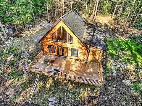 Modern lakefront log cabin with sunset views.