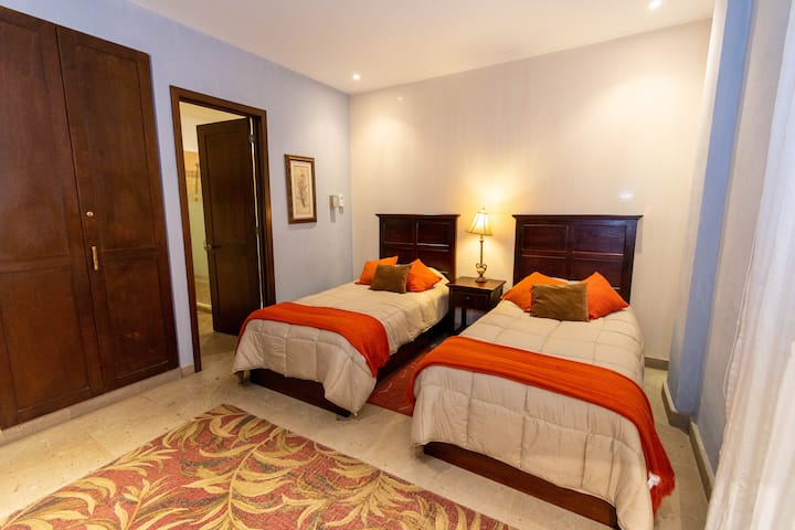 Tercer dormitorio con dos camas individuales y un baño.