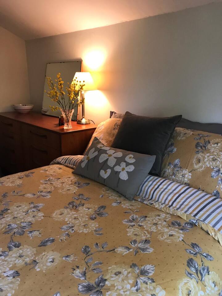 Kitanda cha watu wawili kilicho na sehemu ya kabati la nguo, kiti na meza ya kuvaa. Mwonekano mzuri wa milima , bustani na mashamba 