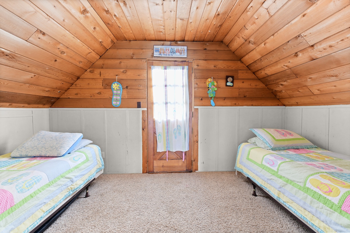 Flip flop room with two twin size beds in loft area.