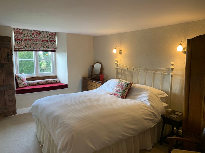 This room pays homage to William Morris.  A king sized double room with slanting floor and spacious en-suite shower room through the tudor latch door and old carved door frame found in the renovations.