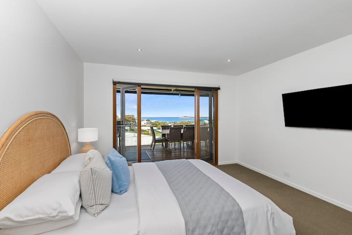 The King size Master bedroom is zoned for privacy on the top floor, embracing beautiful Bluff and ocean views with French doors to the deck. A walk-through robe leads to an ensuite with spa sanctuary vibes.