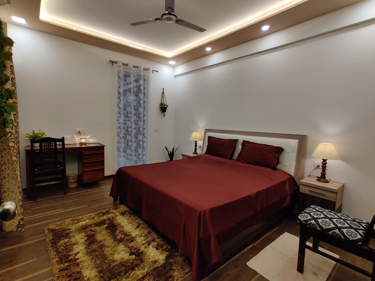 נוף לחדר השינה עם מיטת קינג סייז, מנורת לילה, חדר הלבשה עם מראה גדולה על המעבר, שולחן עבודה