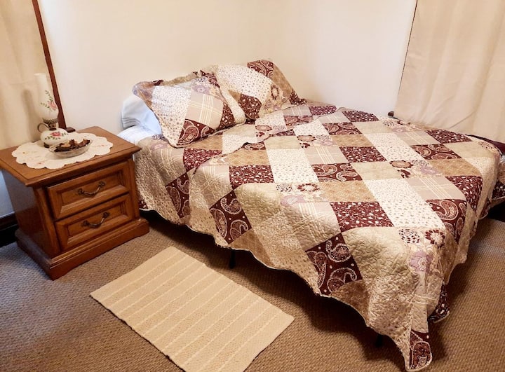 Chumba cha burgandy kina kitanda cha ukubwa wa kifalme. 