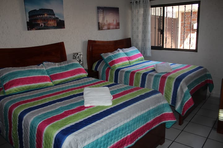 חדר שינה משני שני עם 2 מיטות זוגיות.