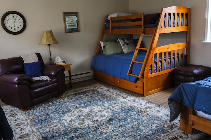 ¡Uno de nuestros lugares favoritos para pasar el rato! Dos camas individuales y una cama de tamaño completo. Área de lectura y escritorio.