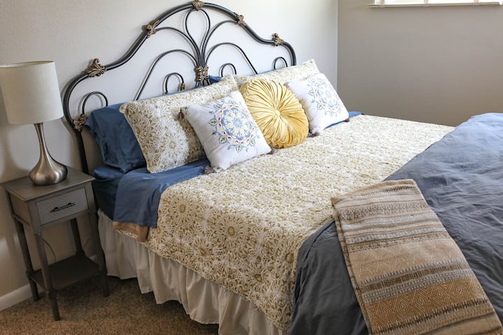 Dormitorio principal con cama tamaño king y baño adjunto con ducha. 