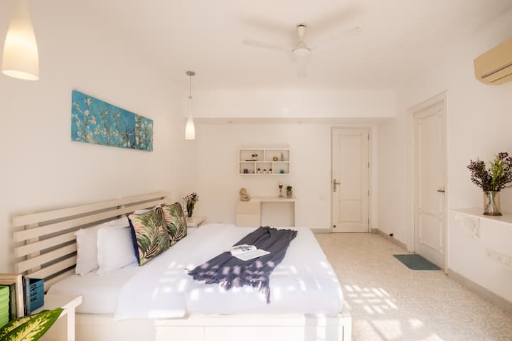 Second Bedroom in pristine white with a study table and balcony , ensuite bathroom. Painting - Almond blossoms by Van Gogh.