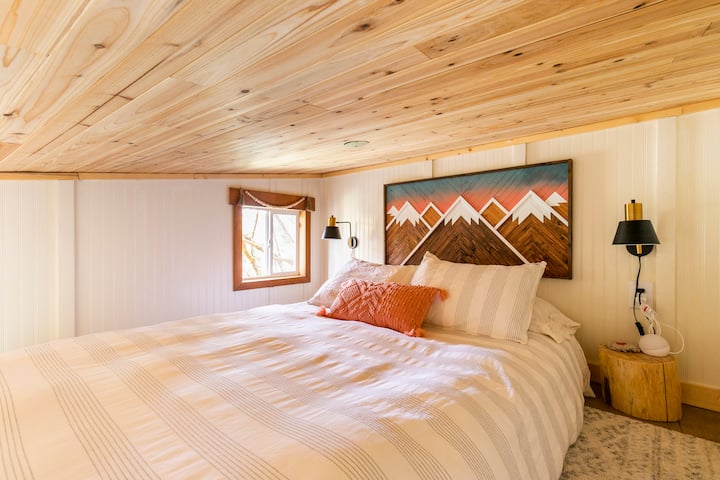 Cozy loft area with stump side tables & reading sconces, as well as a queen bed complete with plush organic cotton bedding 