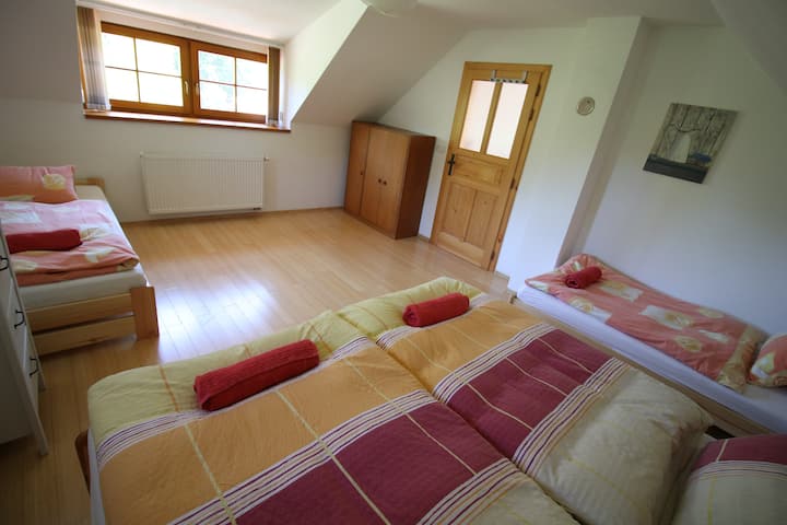 ห้องนอนในคอทเทจมีเตียงคู่และเตียงเดี่ยวสองหลัง