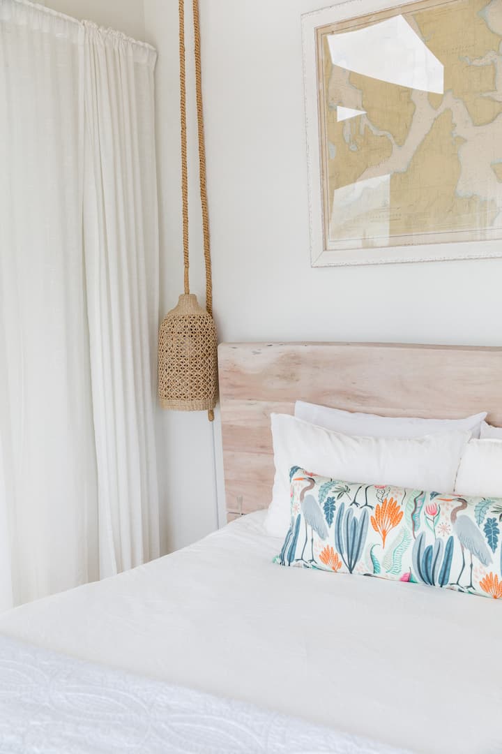 ห้องนอนชั้นล่างพร้อมที่นอนควีนไซส์หรูและวิวน้ำ