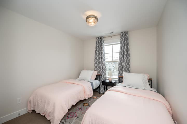 Dormitorio de invitados con dos camas individuales con colchones de espuma viscoelástica, cortinas opacas. Cobijas y almohadas adicionales se guardan en el armario de esta habitación.