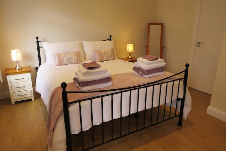 Dormitorio 1. - Habitación tamaño king, baño privado en la planta baja.  Tiene cama tamaño king con colchón Pocket Sprung, armario, cofre de los cajones con espejo de tocador adjunto, espejo largo de pie libre, taquillas junto a la cama con luces y un televisor de 32pulgadas.