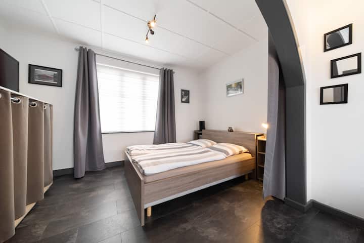 Ruime kamer met twee tweepersoonsbedden van 140 x 200 cm, gescheiden door een groot gordijn