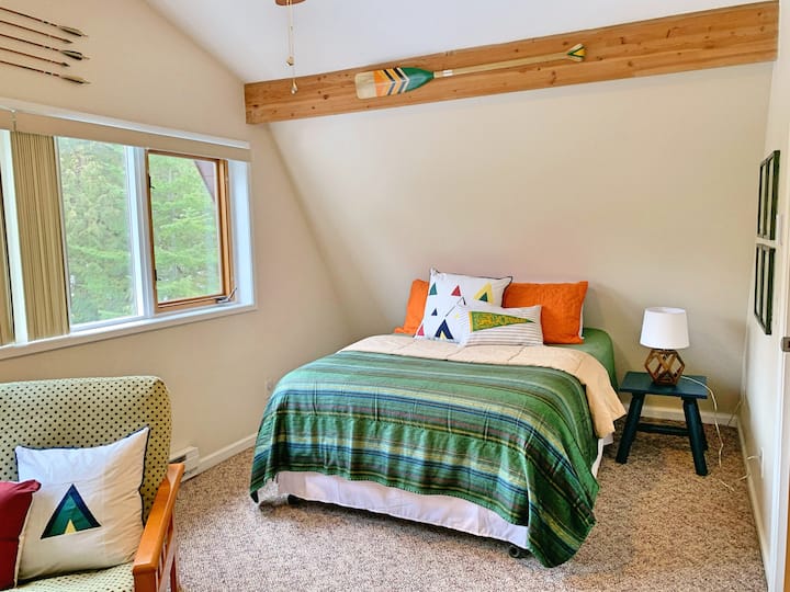 Queen sized bed in second floor bedroom with gaming systems and a futon for extra sleeping space.