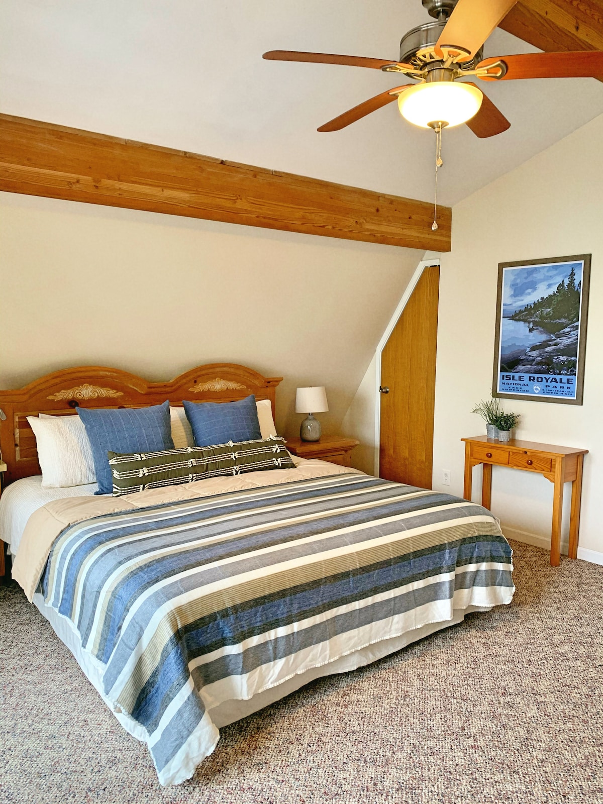 King size bed in second floor bedroom with balcony overlooking the lake and dedicated work space