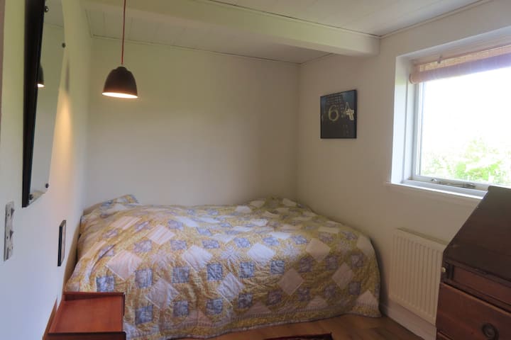 ห้องพักชั้นล่างมีเตียง 2 เตียงครึ่งและมองเห็นทุ่งนา