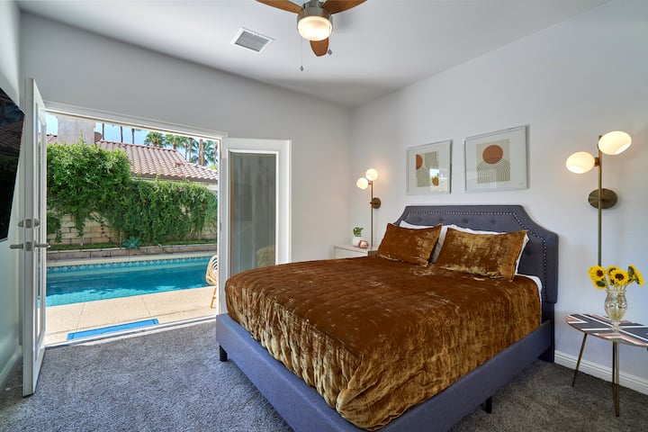 Terza camera da letto con TV a schermo piatto e portefinestre che conducono direttamente alla piscina, alla vasca idromassaggio e al patio posteriore.  Le porte francesi hanno tonalità interne dalla privacy.