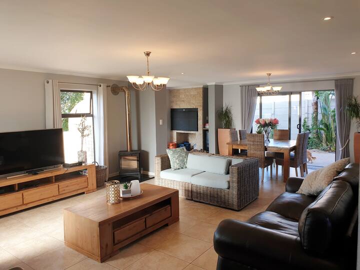 Телевизионна стая с камина, трапезария отзад, с закрит брай и фурна за пица вляво.