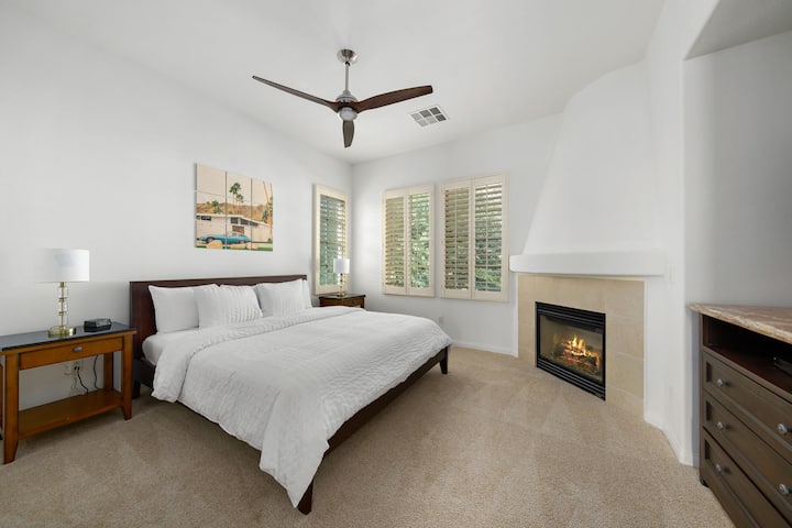 Enorme dormitorio principal con cama tamaño king, chimenea de gas y luz y ventilador. Todo con ventanas con vistas a la piscina cercana y vistas despejadas de las montañas de Santa Rosa.