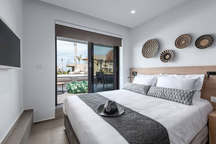 Downstairs bedroom 2 with a modern boho design, opens up directly onto the private pool terrace