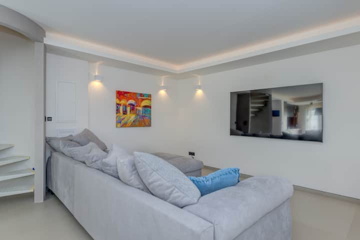 Საცხოვრებელი სივრცე უზარმაზარი გასაშლელი დივნითა და 72-დუიმიანი ტელევიზორით