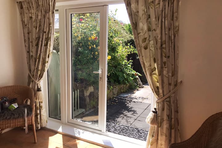The Garden room with Doors to back garden with BBQ &, outdoor dining area. There is TV & warm fire for rainy cooler days.