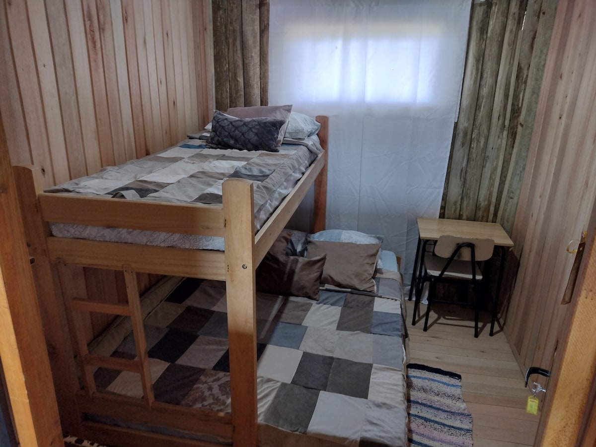 เตียงสองชั้นพร้อมเตียงเดี่ยวเตียงคู่และโต๊ะพร้อมเก้าอี้