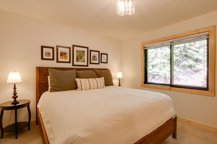 The house has two bedrooms and a bathroom on each floor. The upstairs primary bedroom has a king bed, bedside tables, and plenty of outlets.