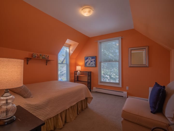 غرفة نوم بسرير بحجم كبير في الطابق العلوي.