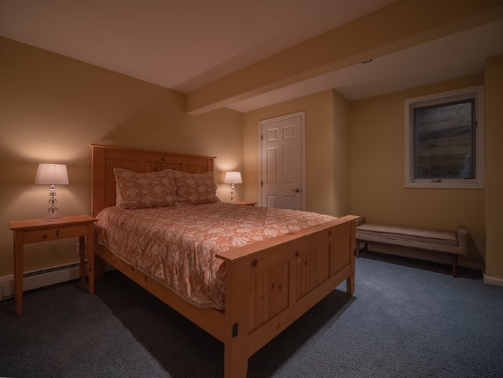 غرفة نوم بمقاس كبير بمستوى أقل.