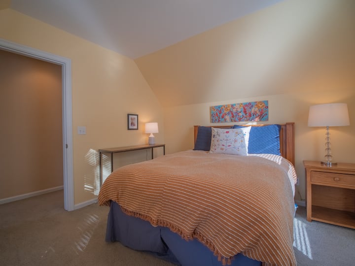 غرفة نوم بسرير بحجم كبير في الطابق العلوي.