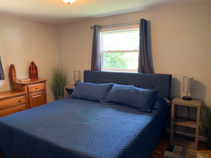 Dormitorio 1 con cama tamaño king, vestidor, armario y lámparas con tomas de corriente USB y de alimentación.