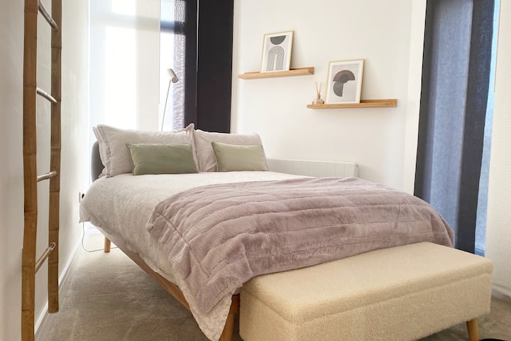 غرفة نوم رئيسية مع حمام داخلي خاص وسرير مزدوج مريح وستارة سوداء وفراش فاخر ومناشف ناعمة.