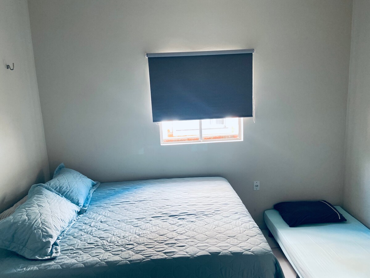 Suite met queensize bed en eenpersoonsbed, met eigenaren voor twee hangmatten, airconditioning, badkamer met elektrische douche. 