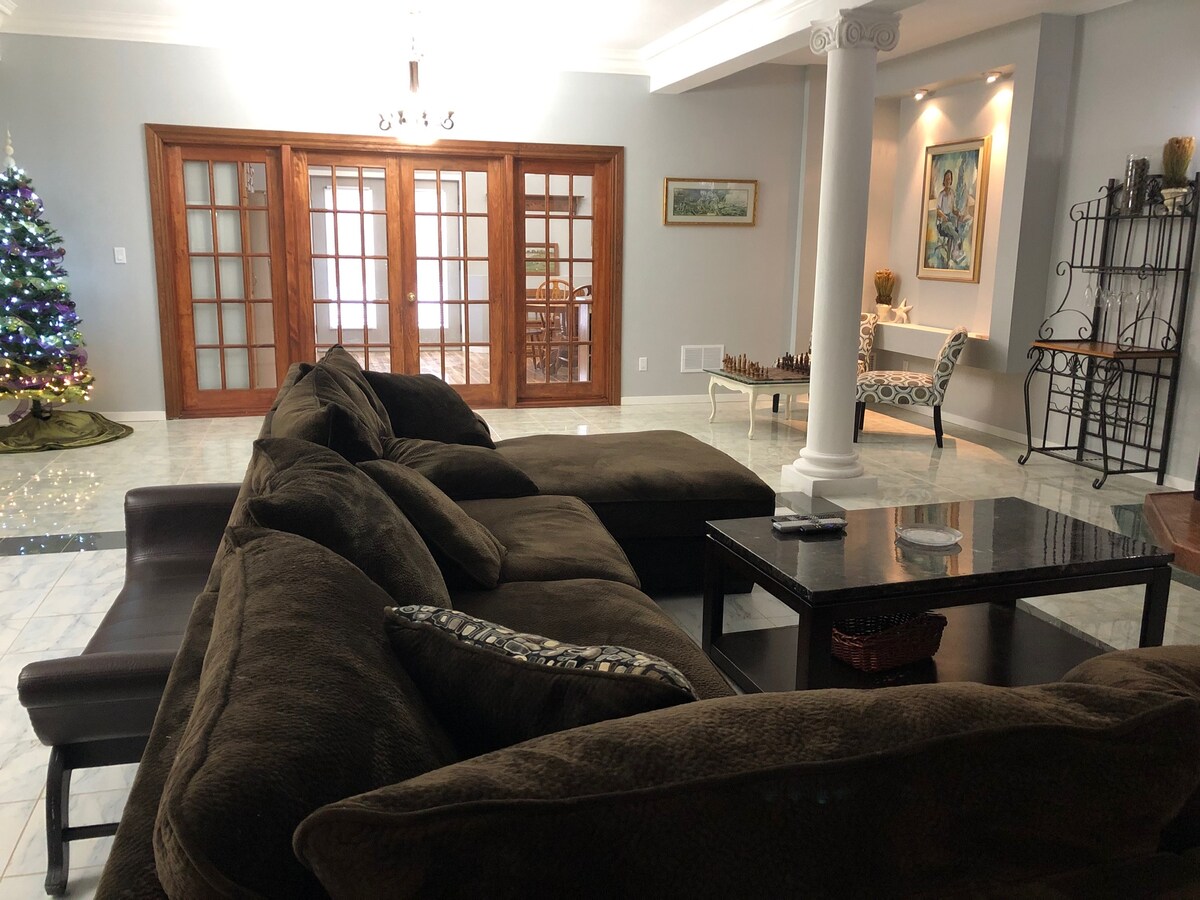 มองไปทางห้องครัวห้องนั่งเล่นมีขนาด 36 ’คูณ 29’ พร้อมเพดาน 10 ฟุต โซฟาแบบแยกส่วนที่กว้างขวางมากเหมาะสำหรับการพักผ่อนขณะดูทีวีหรือเพลิดเพลินกับเสียงเพลงด้วยระบบเสียงรอบทิศทาง