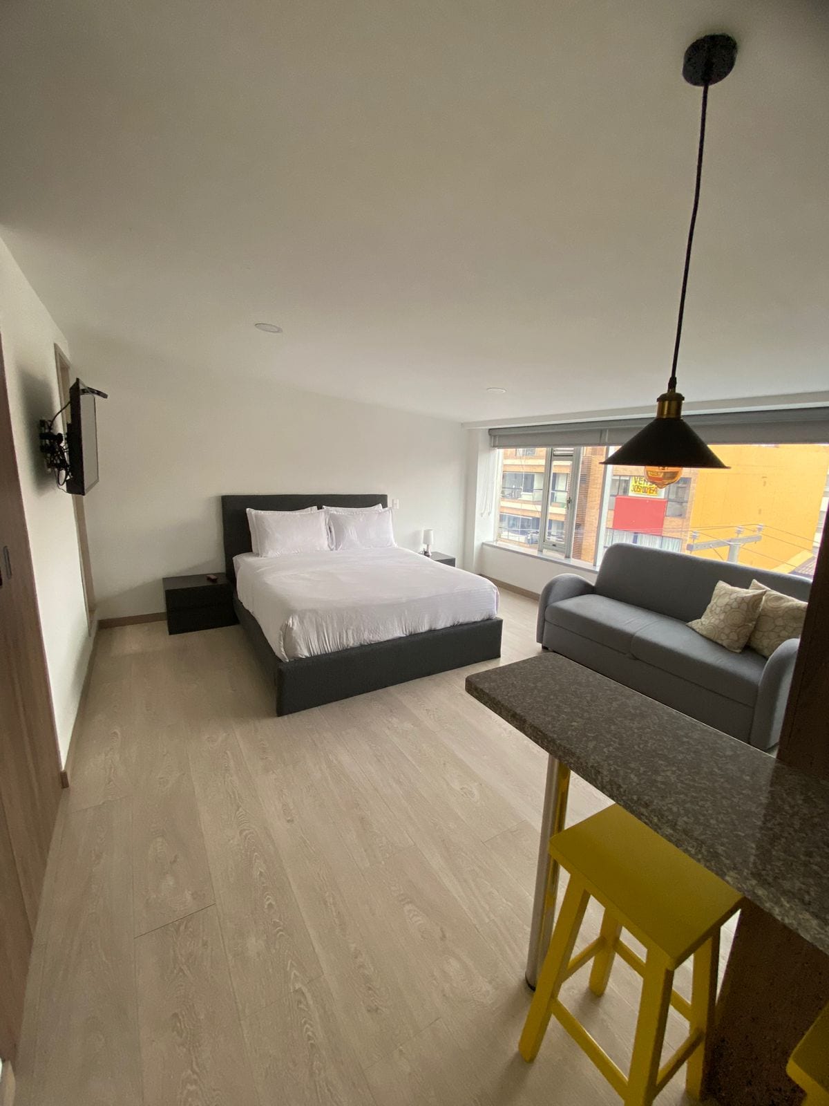 מיטת קווין סייז נוחה עם מיטת הלבשה תחתונה לבנה, ספה נפתחת לשניים.