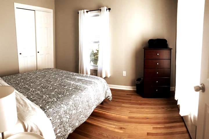 Treetop - Bedroom 1 is a corner bedroom with two windows, a queen bed, and an overhead fan.