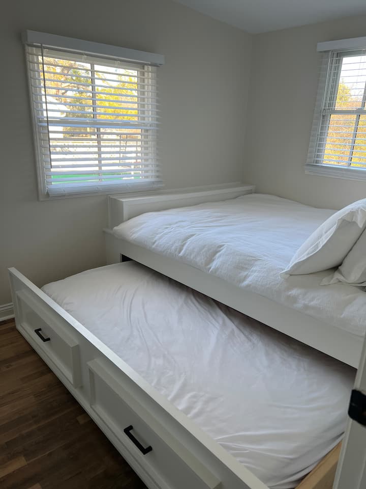 Camera da letto per gli ospiti con letto matrimoniale e letto estraibile, tavolino e smart TV